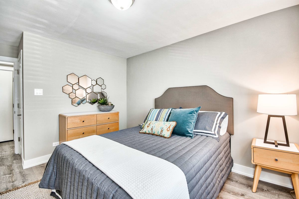 Resident bedroom with a bed and nightstand at The Maynard at 2545 W Fitch in Chicago, Illinois