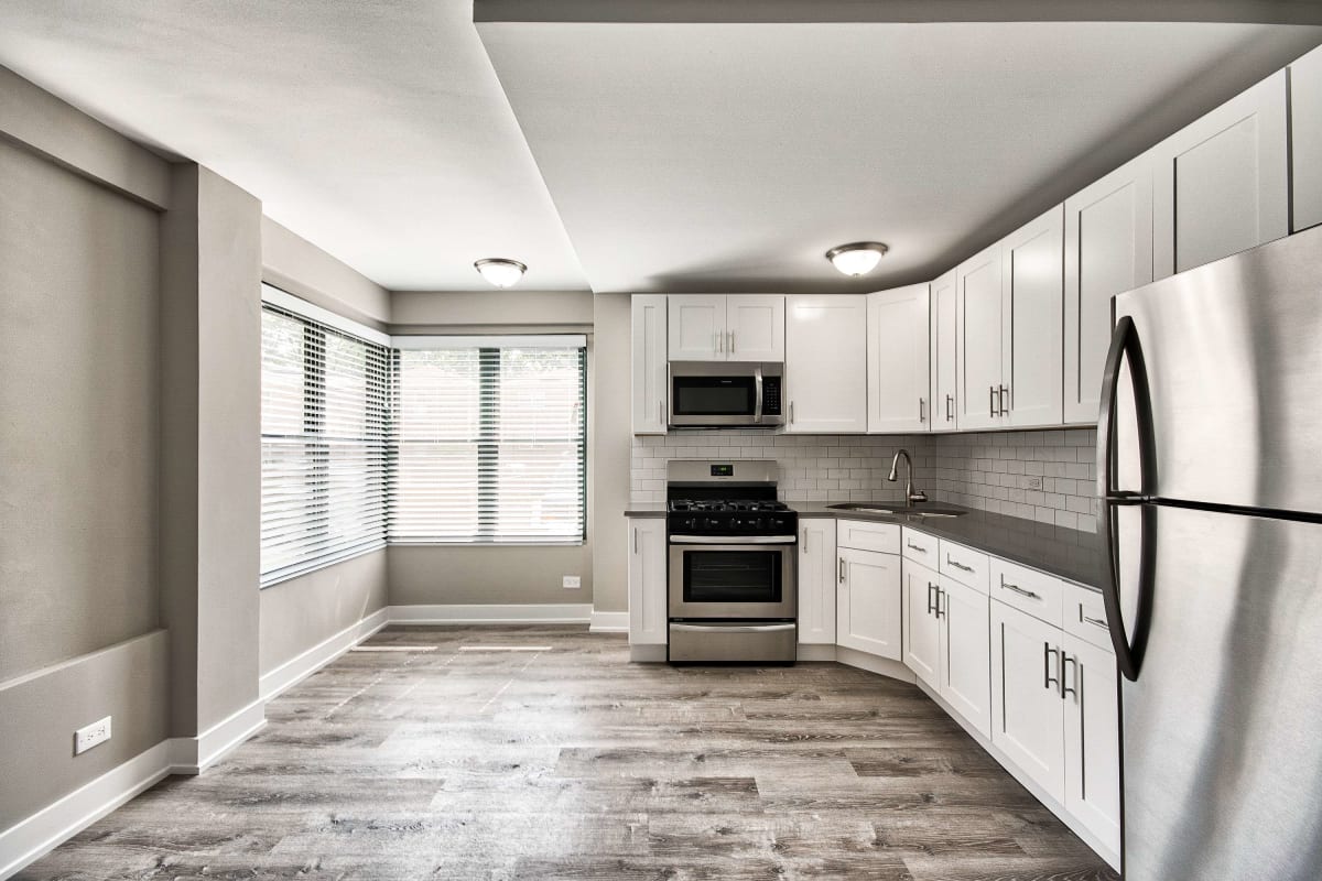 Resident modern kitchen with wood-style flooring at The Maynard at 2545 W Fitch in Chicago, Illinois