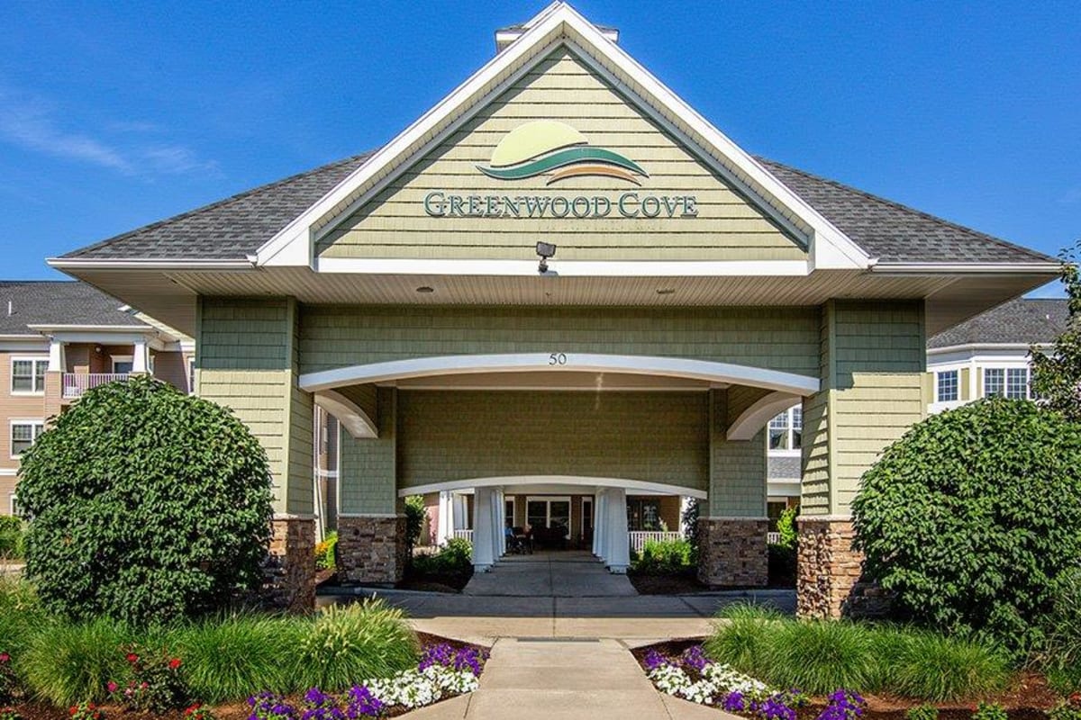 Exterior clubhouse entrance view with beautiful landscaping at Greenwood Cove Apartments in Rochester, New York