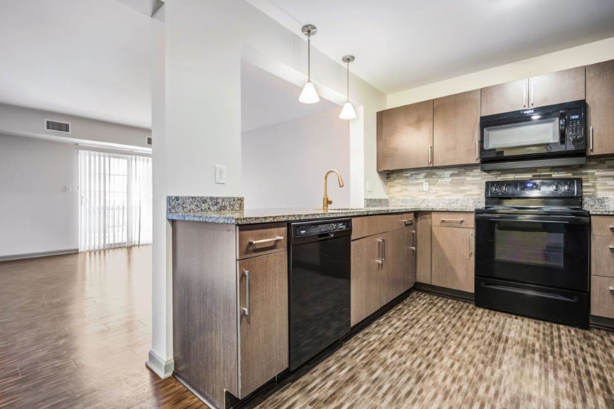 Large modern kitchen open to living room with patio access at Greenwood Cove Apartments in Rochester, New York