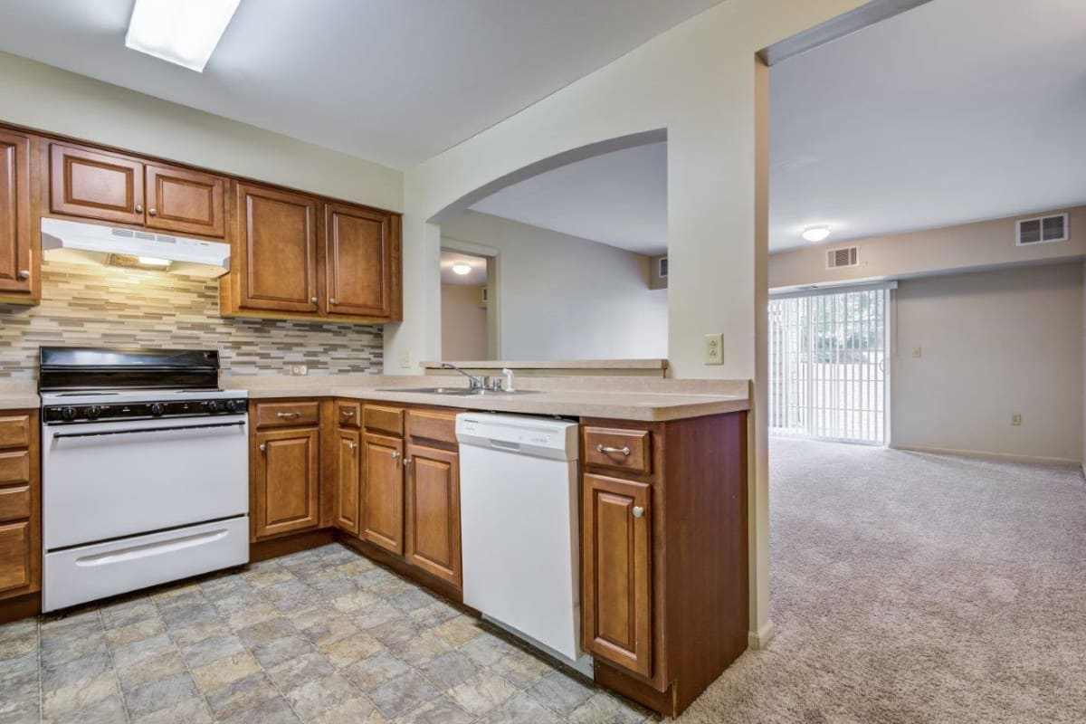 Large kitchen open to living room with patio access at Greenwood Cove Apartments in Rochester, New York