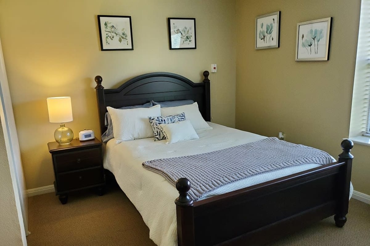Bedroom with large bed and end table with lamp at Wildflower Place in Temple, Texas