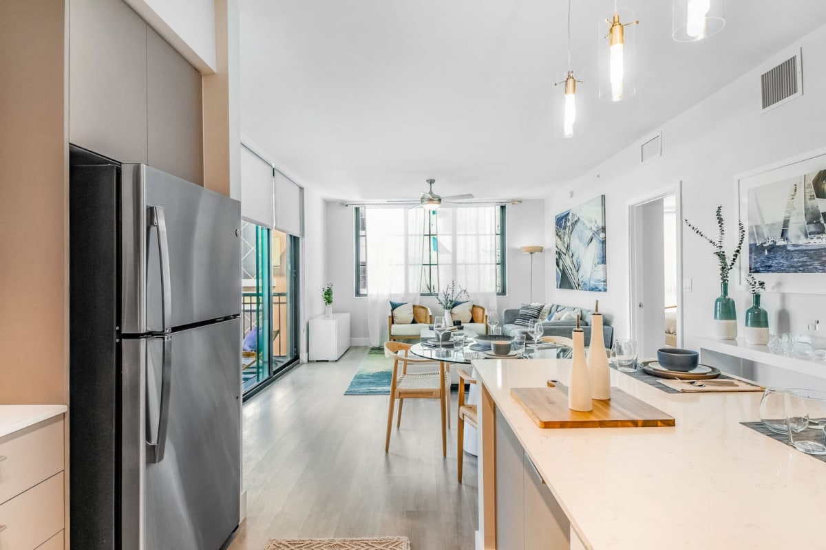 Stainless-steel appliances in an apartment kitchen and a furnished living room at Marina Del Viento in Sunny Isles Beach, Florida