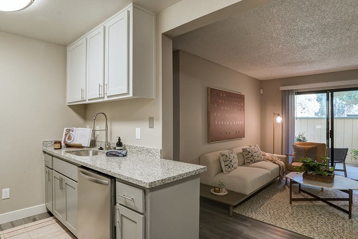 Stylish modern kitchen and living room at Austin Commons Apartments in Hayward, California