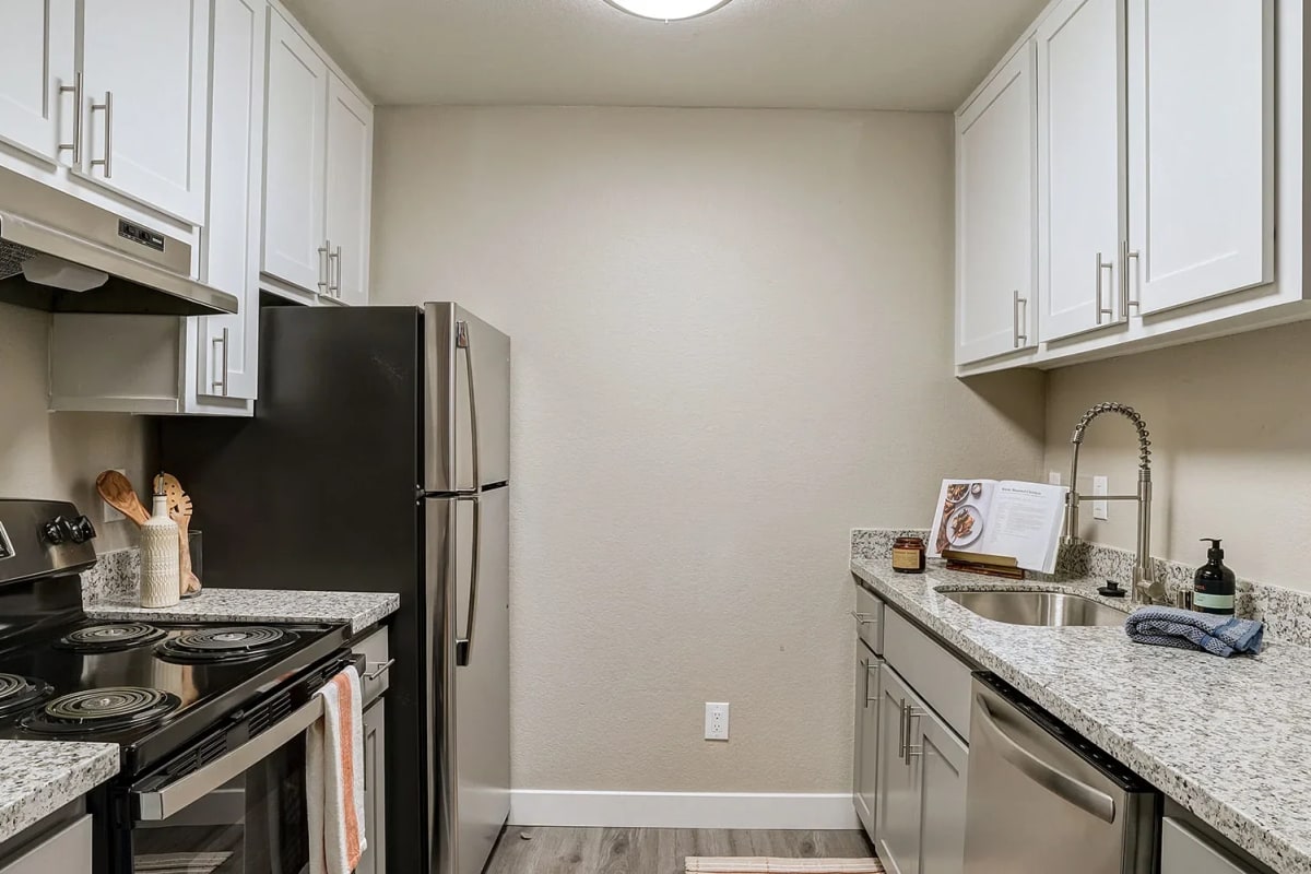 Sleek, modern kitchen with island seating at Austin Commons Apartments in Hayward, California
