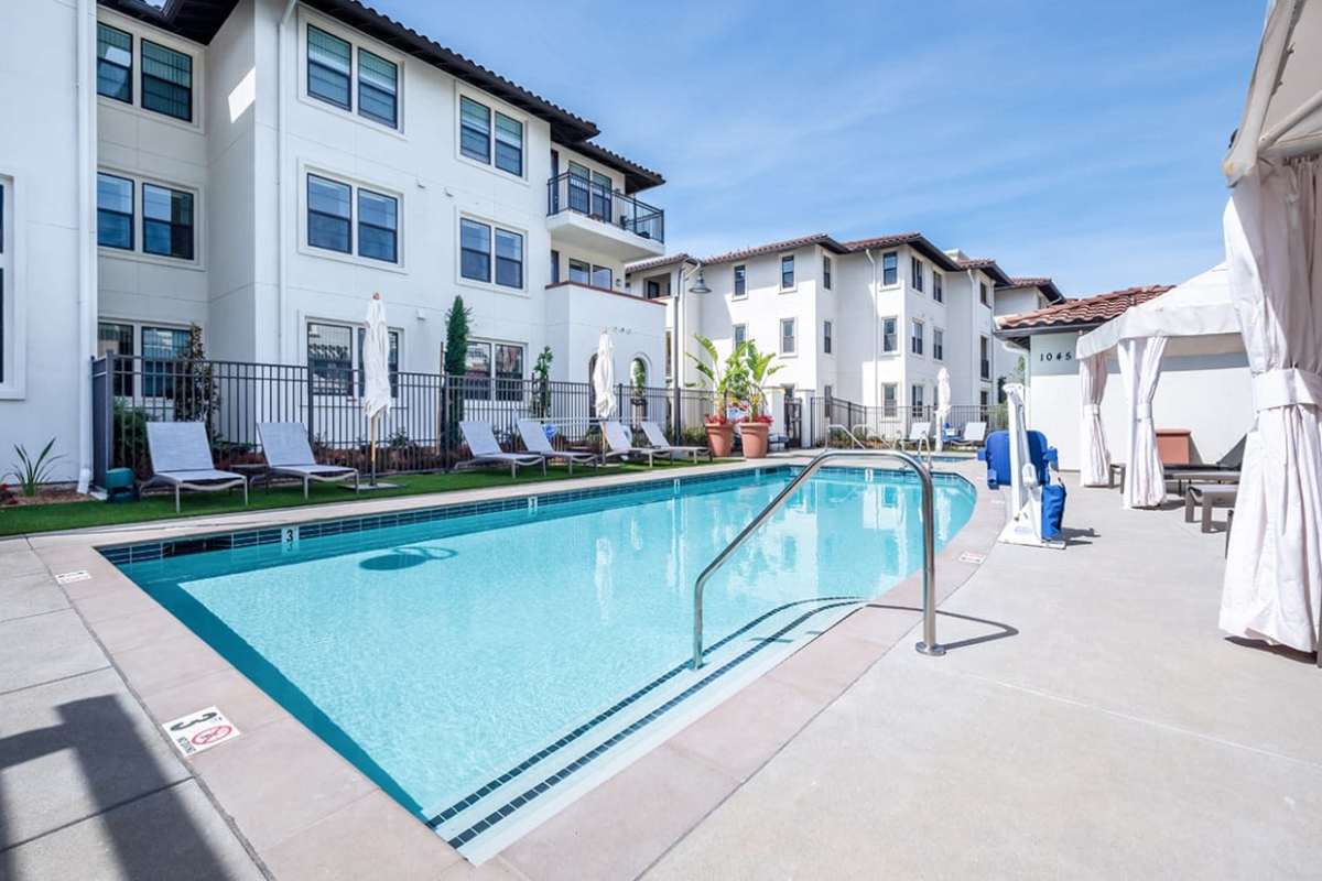 Deck chair around outdoor swimming pool at Ageno Apartments in Livermore, California