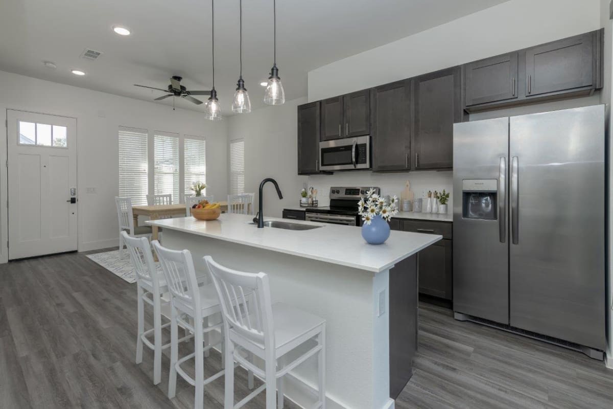 Modern kitchen with center island and new appliances at Elevate at Skyline in McKinney, Texas