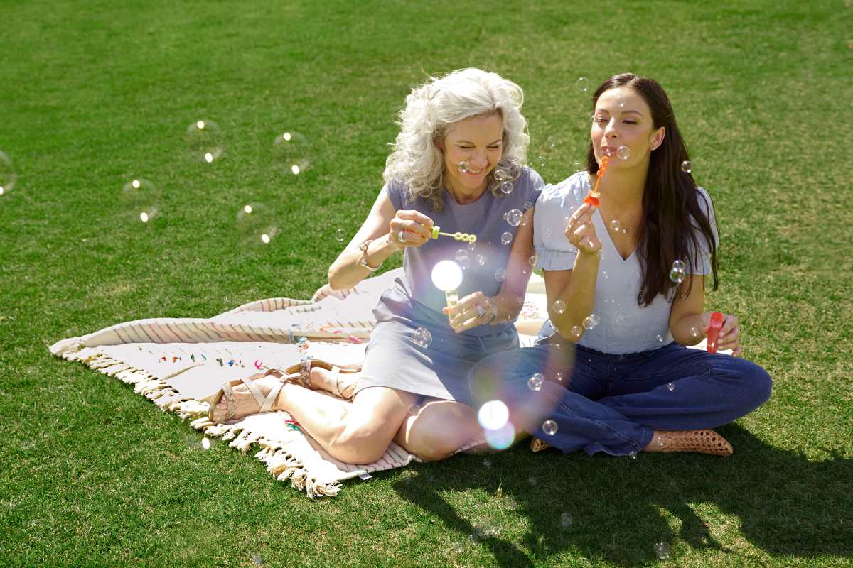 Woman and her mother blowing bubbles on the lawn at BB Living Wellen Park in Venice, Florida