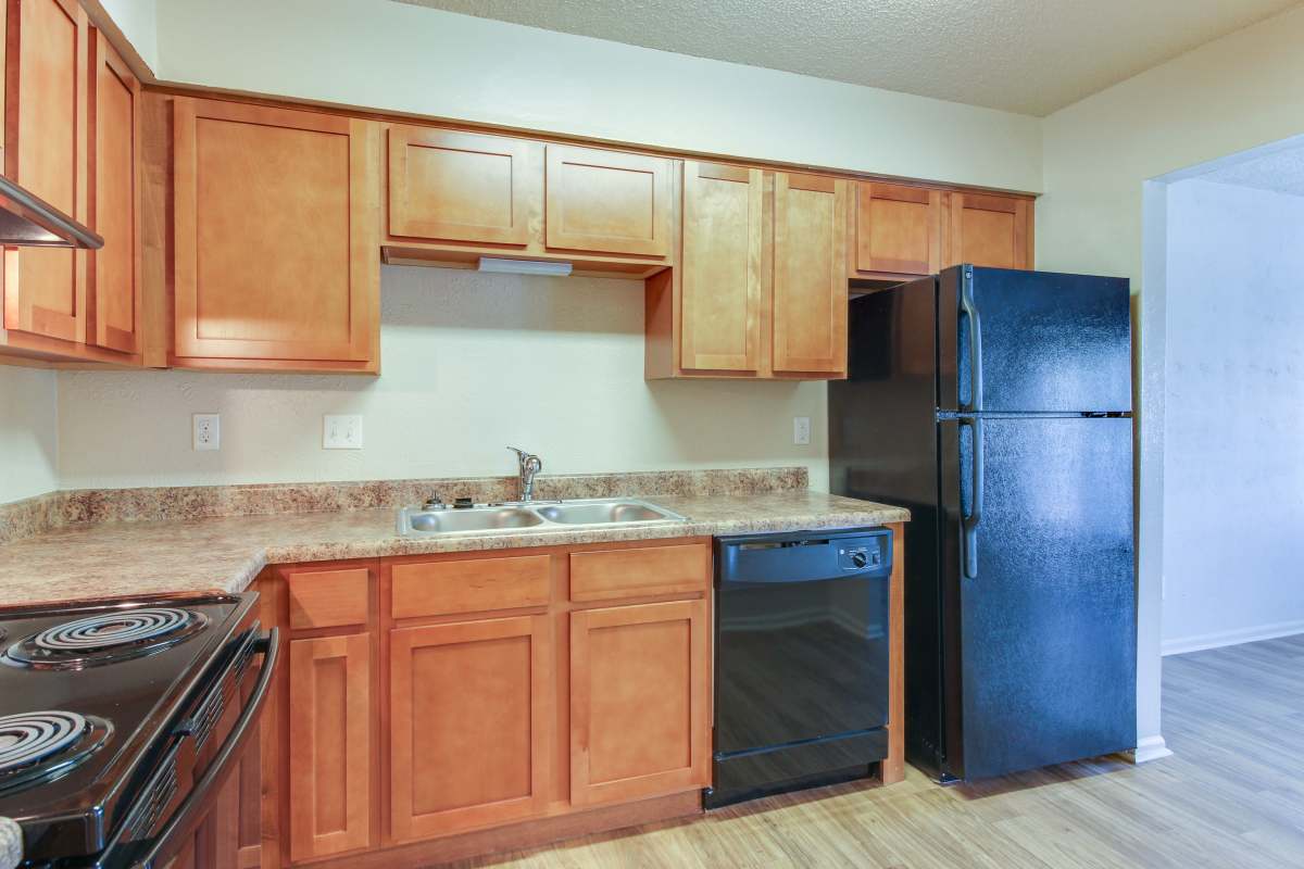 Apartment kitchen with black appliances and wood flooring at Hickory Lake in Antioch, Tennessee