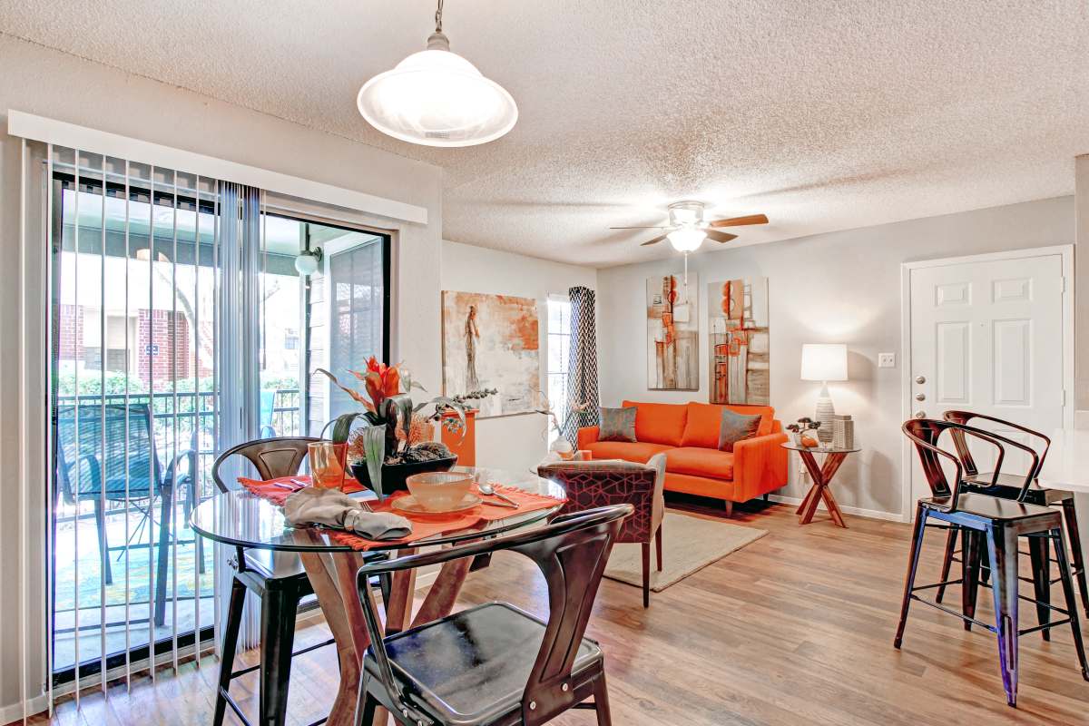 Dining area and living room with wood-style flooring at The Flats on San Felipe in Austin, Texas