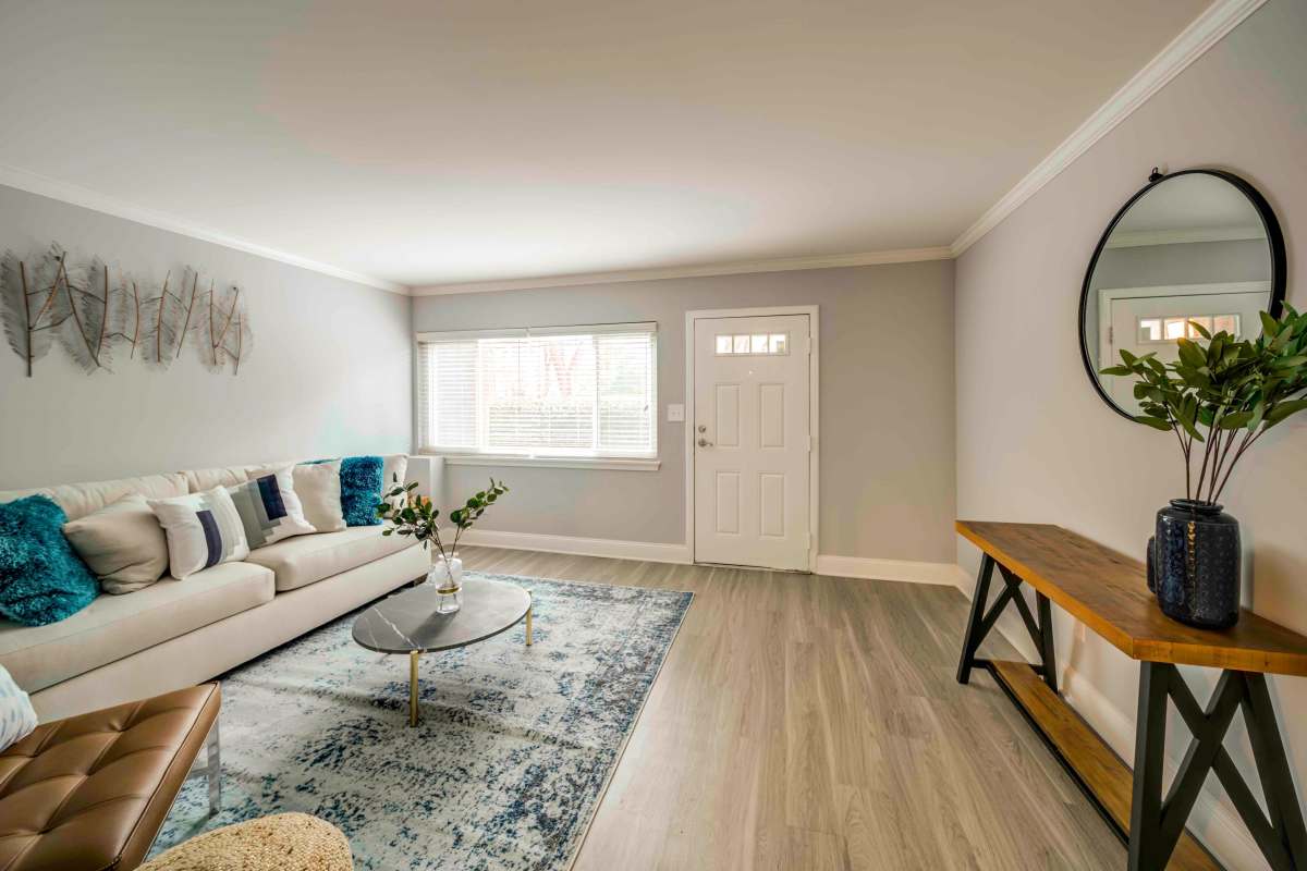Apartment living room with wood-style flooring at The Trails of North Hills in Raleigh, North Carolina