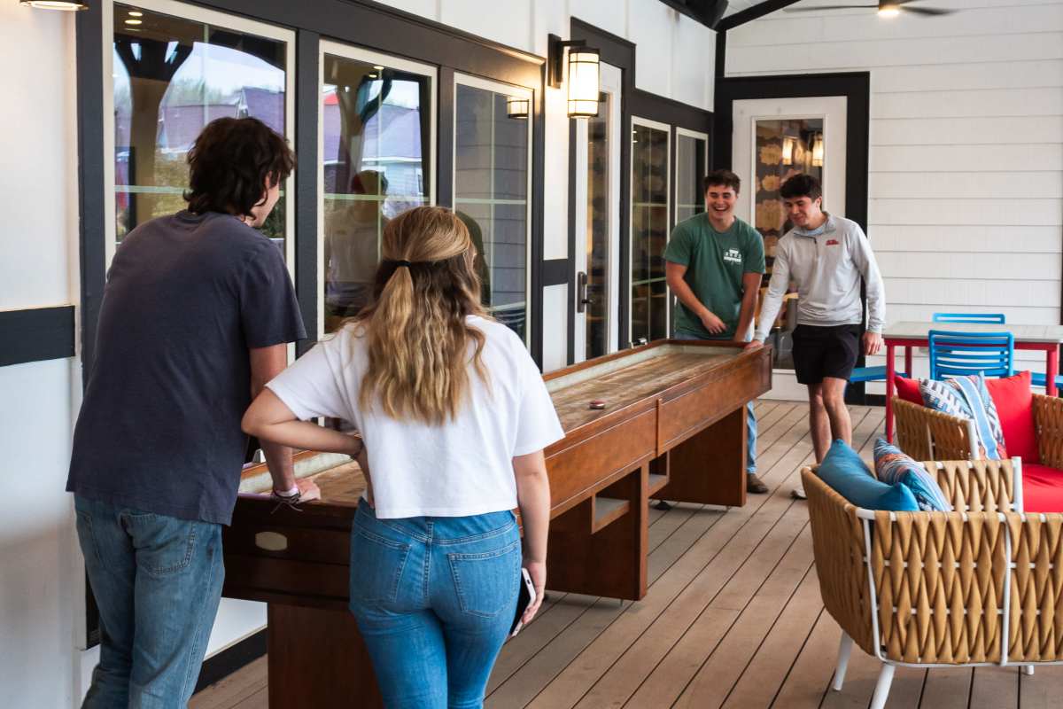 Friends playing shuffle board at College Town Oxford in Oxford, Mississippi
