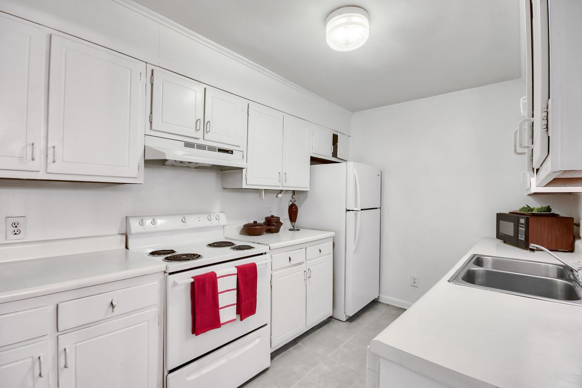 White kitchen with red accents and dishwasher at Sedgefield in Florence, South Carolina