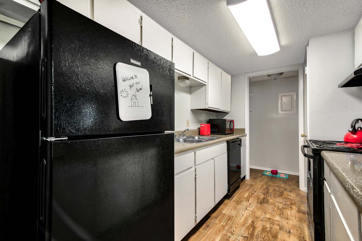 Modern kitchen with wood-style flooring at Sherwood Acres in Baton Rouge, Louisiana