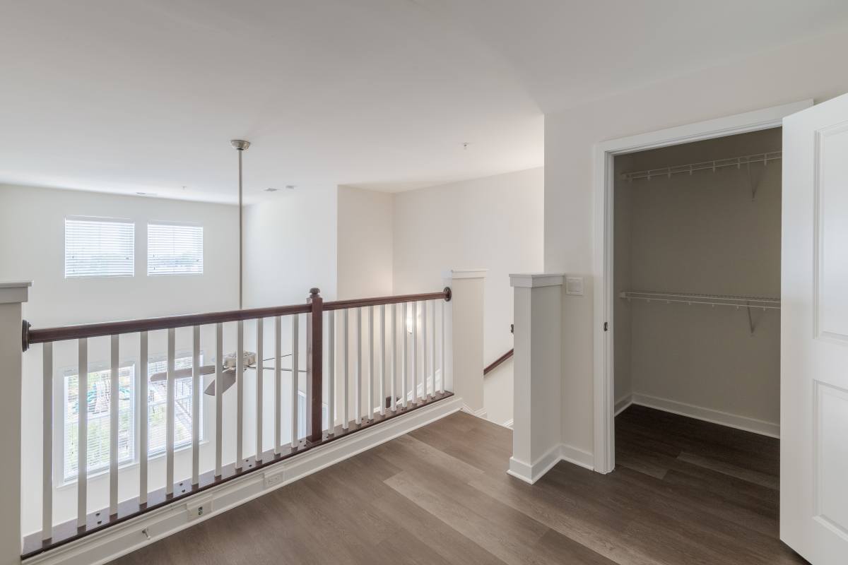 A hallway with a railing and a doorat The Tala at Washington Hill in Baltimore, Maryland