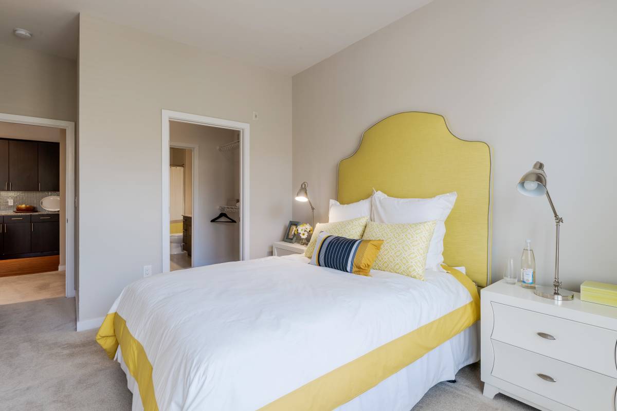 A bed with yellow and white bedding at The Tala at Washington Hill in Baltimore, Maryland