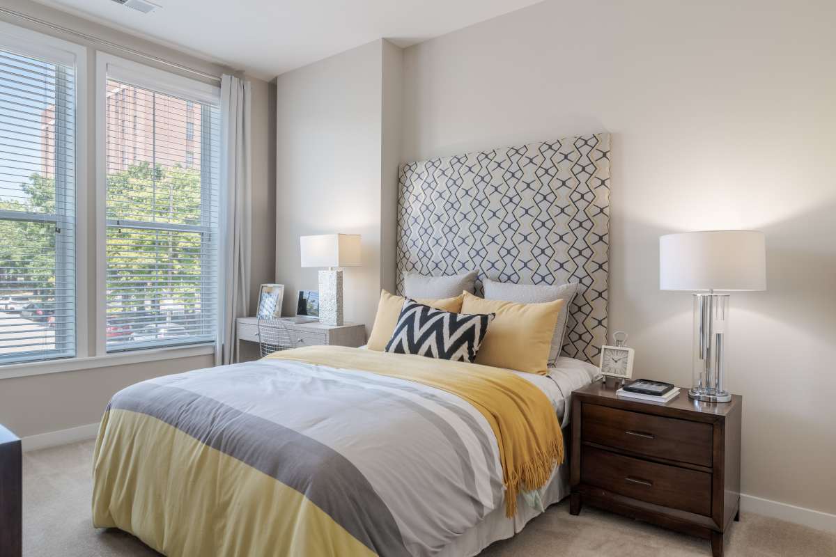 A bed with a yellow and grey blanket at The Tala at Washington Hill in Baltimore, Maryland