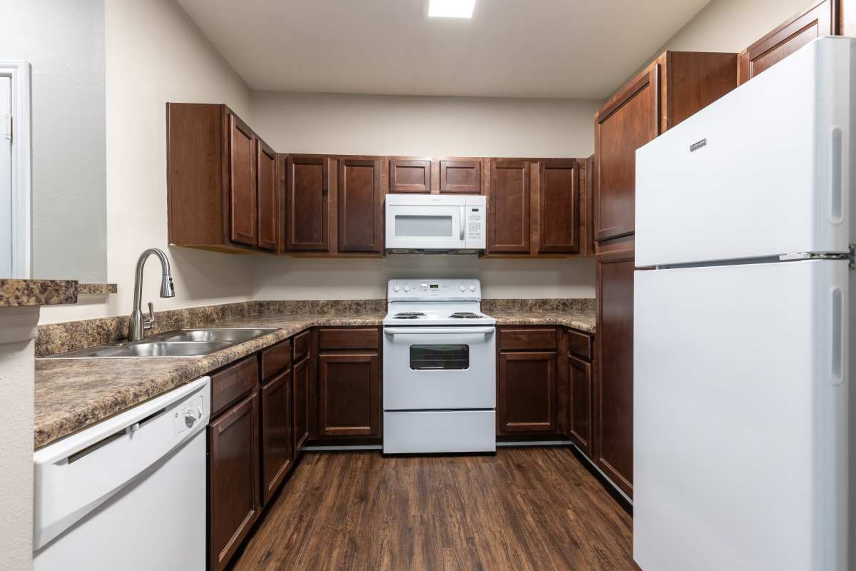 Kitchen with white appliances and espresso cabinets at Sugar Mill in Addis, Louisiana