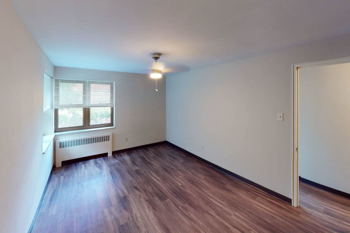 Spacious bedroom with wood-style flooring at Lebanon Vue in Pittsburgh, Pennsylvania