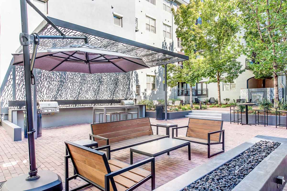 outdoor lounge with wooden chairs and an oversized umbrella