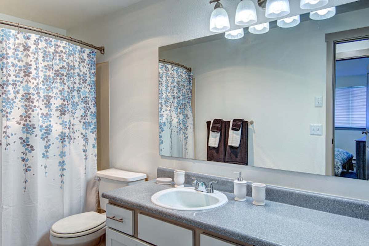 Bathroom with waterfall faucet sink, storage space and bath tub at Briarstone in Tacoma, Washington