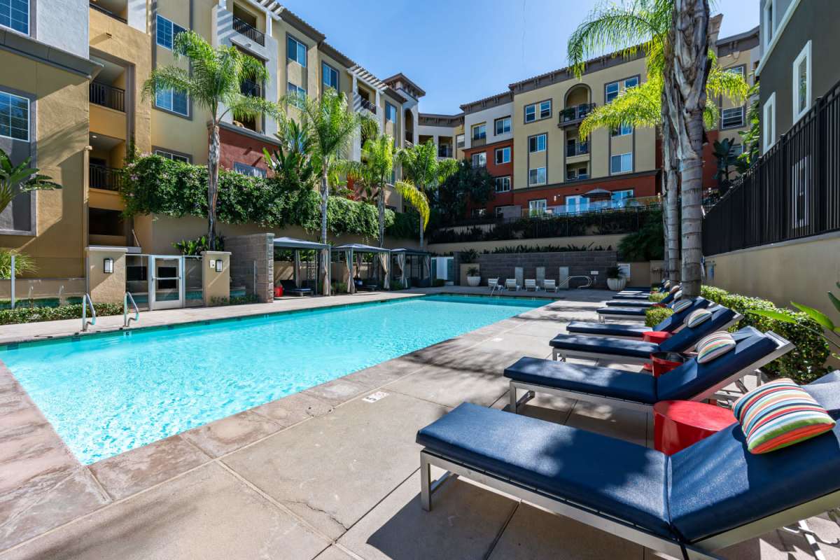 Pool area with lounge chair at The Boulevard Apartment Homes in Woodland Hills, California