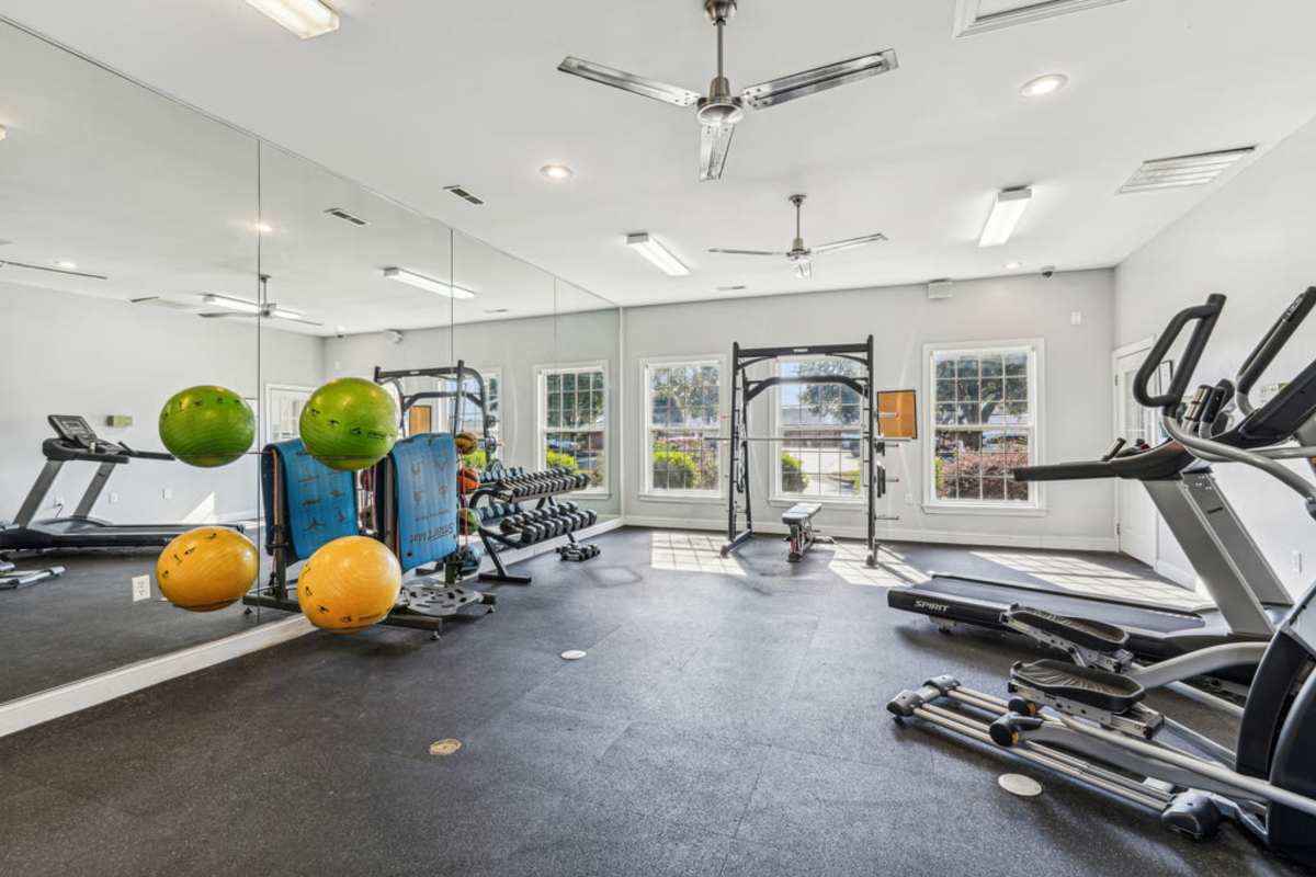 Fitness center with windows showing the scenery outdoor at Woodland Crossing Apartment Homes in New Bern, North Carolina