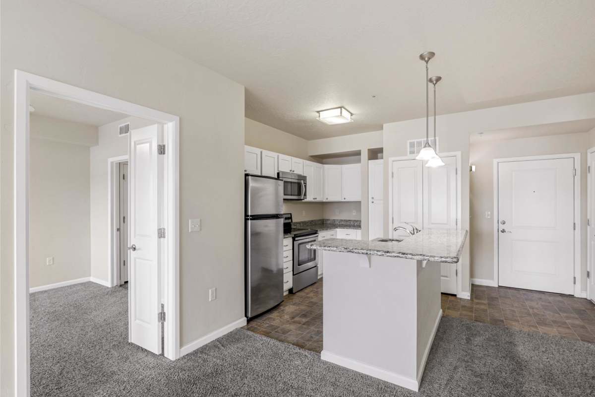 Kitchen with view to unfurnished bedroom at Sugar Flats in Salt Lake City, Utah
