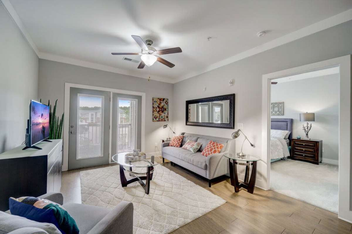 Another angle of spacious living room showcasing the sofa facing the television at Century Park Place in Morrisville, North Carolina