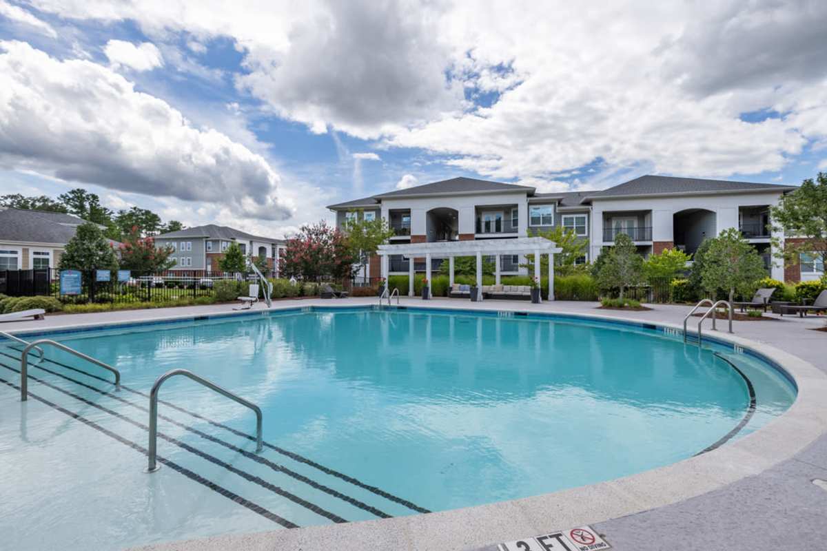 The pool surrounded by greenery, offers a serene atmosphere at Century Park Place in Morrisville, North Carolina
