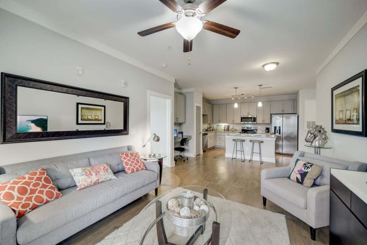 Another angle of the living room showcasing the kitchen area and a small working space near the kitchen at Century Park Place in Morrisville, North Carolina