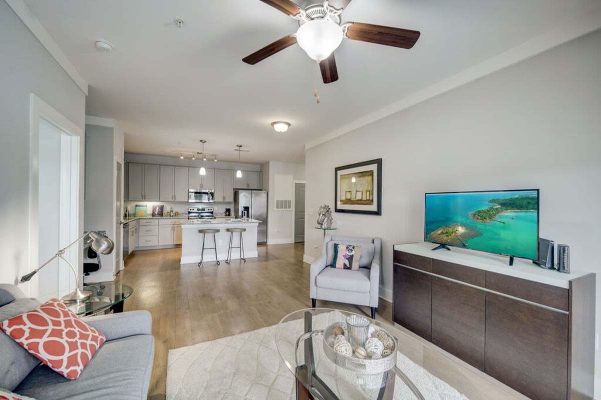 A modern living room showcasing the kitchen area at Century Park Place in Morrisville, North Carolina