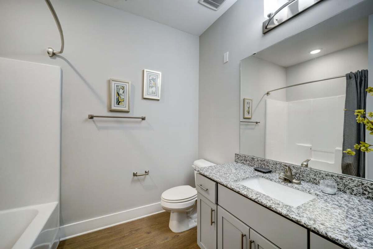 A bathroom with a single sink and toilet bowl and a bath tub at Century Park Place in Morrisville, North Carolina