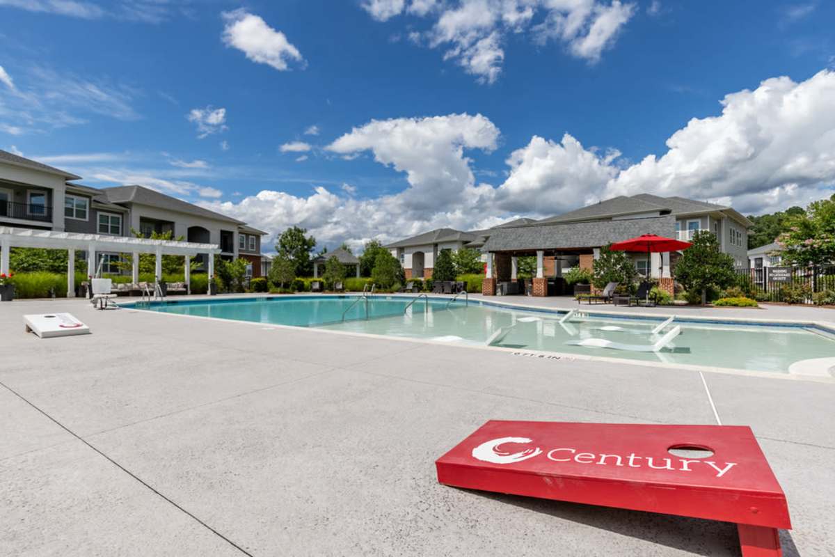 The pool area featuring lounge chairs and a clear blue water surfaceat Century Park Place in Morrisville, North Carolina