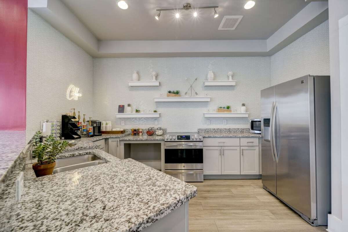A modern kitchen featuring sleek granite countertops and stainless steel appliances at Century Park Place in Morrisville, North Carolina