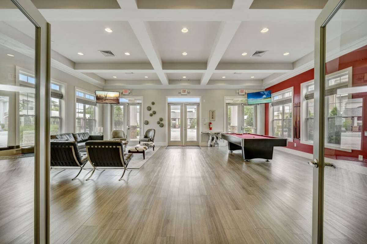 Living room featuring modern furnishings and large windows with views of the surrounding nature at Century Park Place in Morrisville, North Carolina