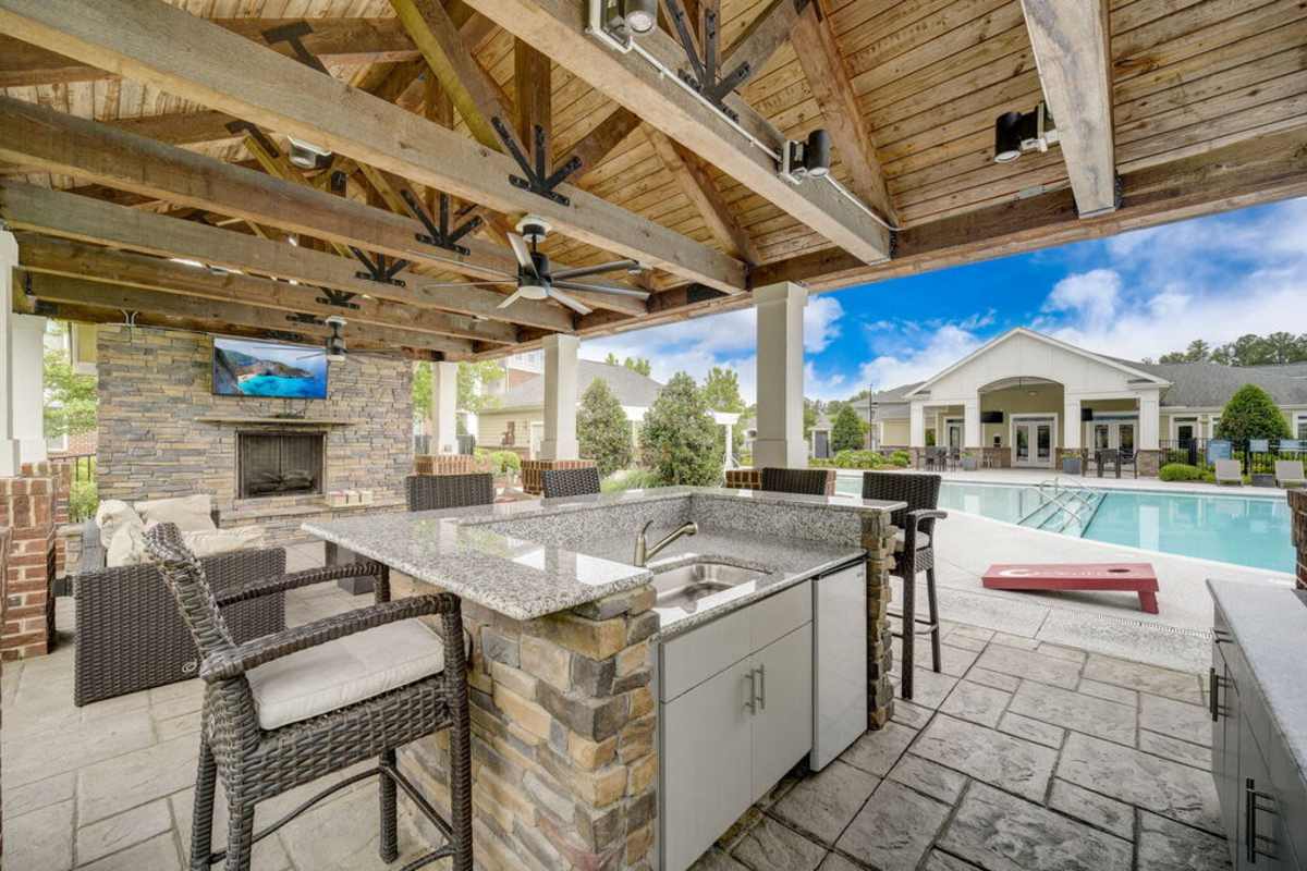 Outdoor kitchen featuring modern appliances and a scenic view of the surrounding landscape at Century Park Place in Morrisville, North Carolina