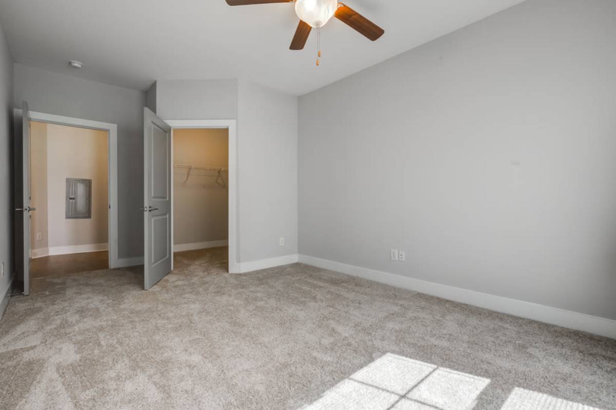 An empty room that showcases doors going to the closet and living room at Century Park Place in Morrisville, North Carolina