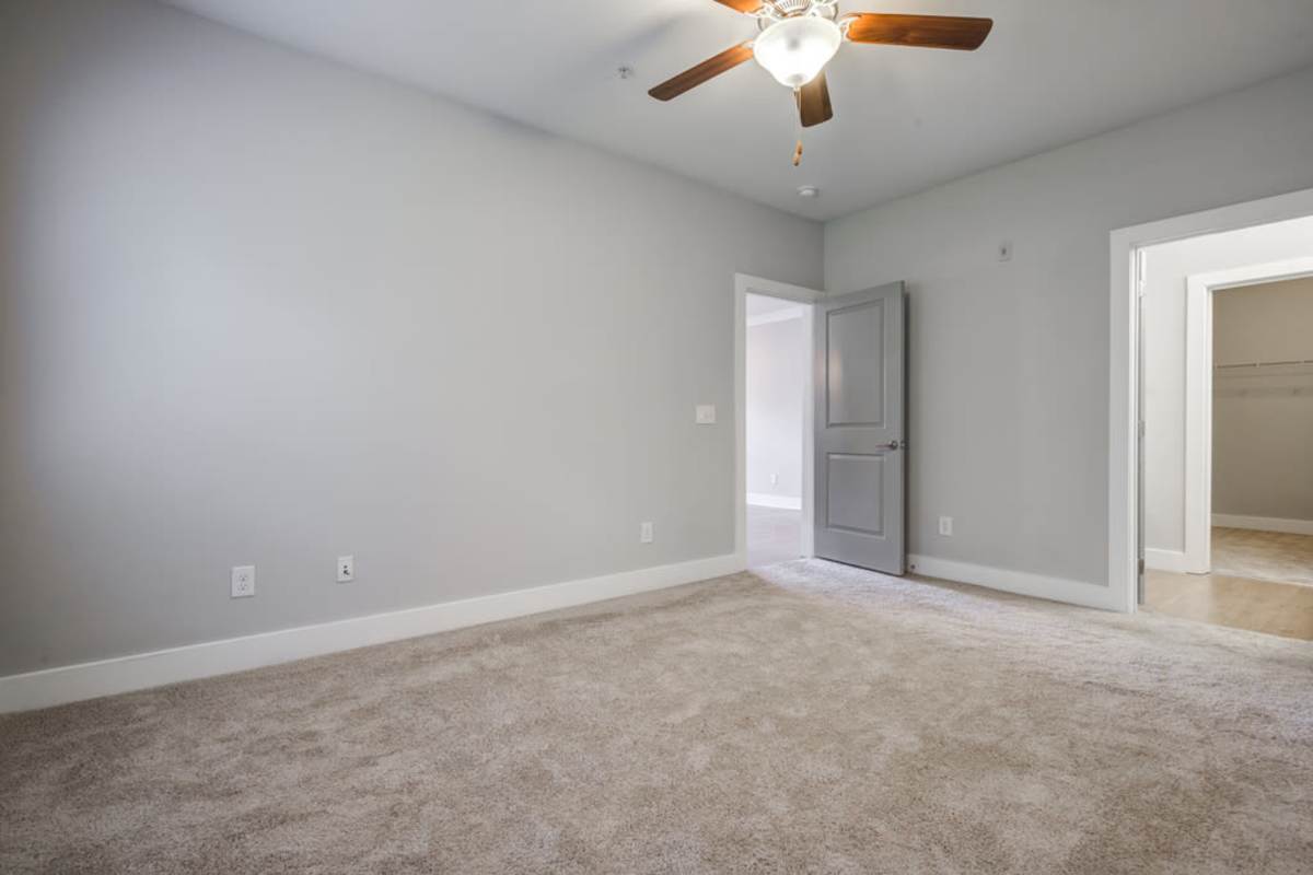 Empty spacious room with gray painted walls with a closet at Century Park Place in Morrisville, North Carolina