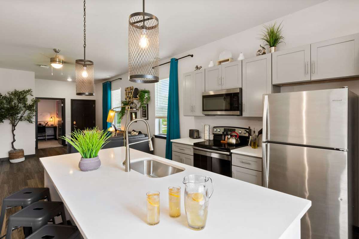 Well-equipped kitchen with range, refrigerator and wooden cabinets at Atlas on 17th in Bloomington Indiana