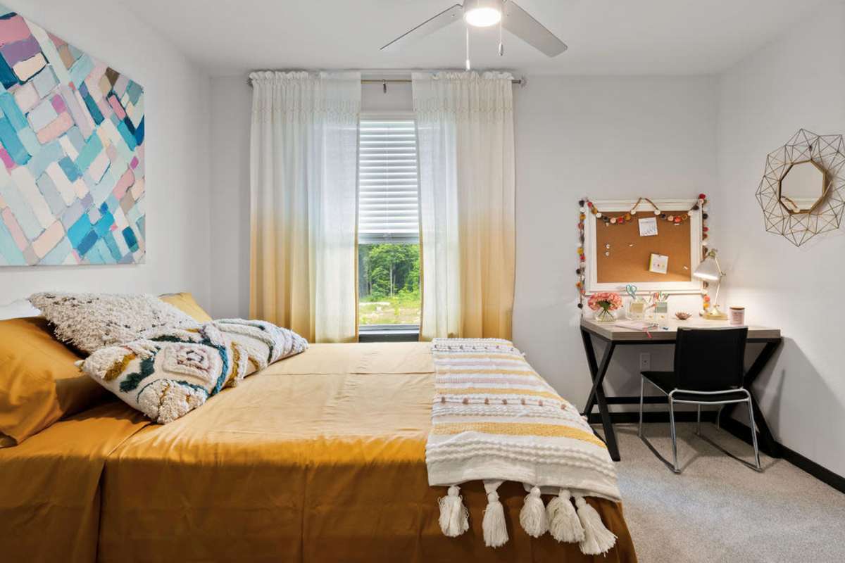 Bedroom with a large bed and windows at Atlas on 17th in Bloomington Indiana