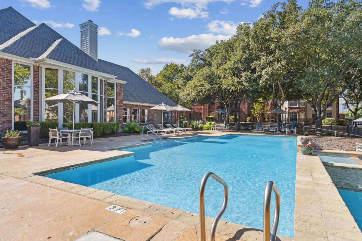 Serene Swimming Pool With Lounge Chairs And Lush Greenery at Whispering Creek Villas, San Antonio, Texas