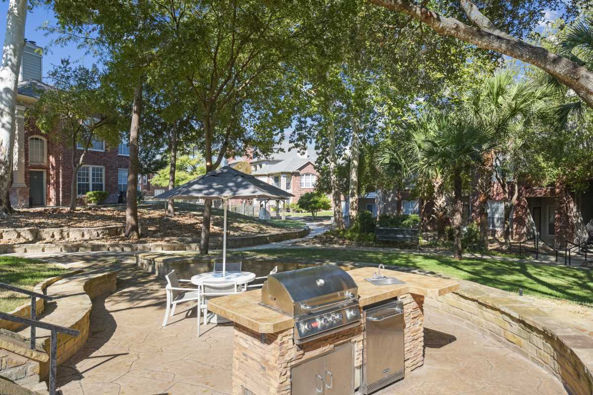 Outdoor Grill Station With Seating Under Shady Trees at Whispering Creek Villas, San Antonio, Texas