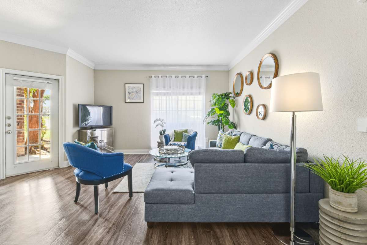 Cozy Living Room With A Gray Sectional Sofa And Blue Accents at Whispering Creek Villas, San Antonio, Texas