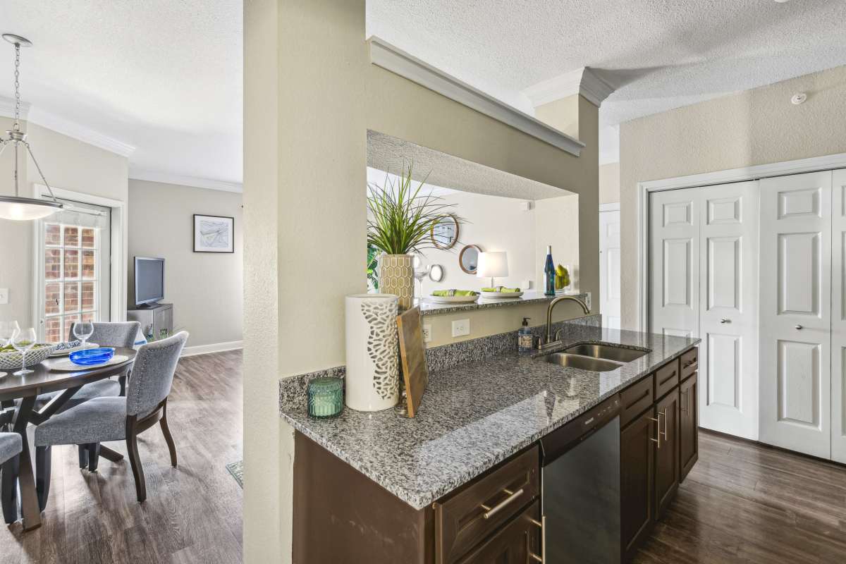 Modern Kitchen Counter With A Sink And A View Of The Dining Area at Whispering Creek Villas, San Antonio, Texas