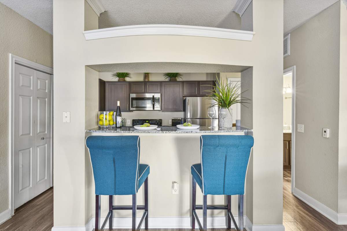 Kitchen Bar With Blue Upholstered Stools And Granite Countertops at Whispering Creek Villas, San Antonio, Texas