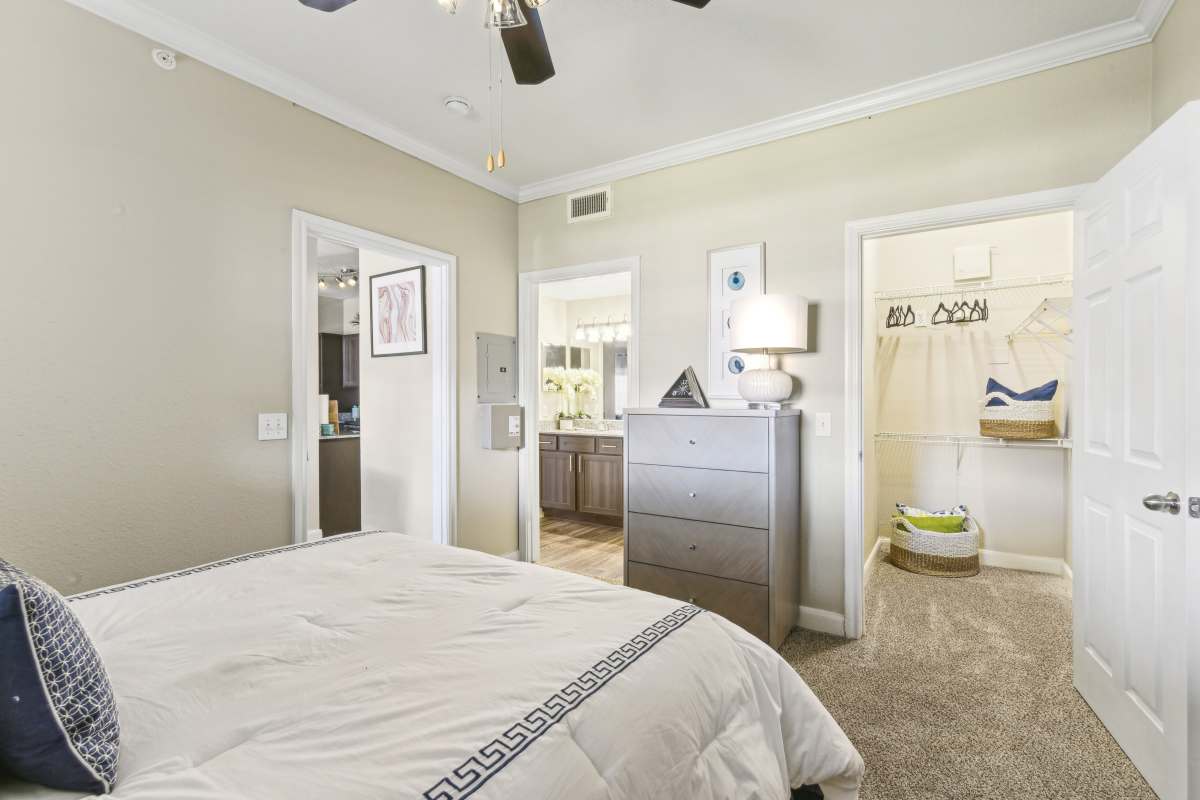 Cozy Bedroom With A Dresser And Entrances To The Bathroom And Closet at Whispering Creek Villas, San Antonio, Texas