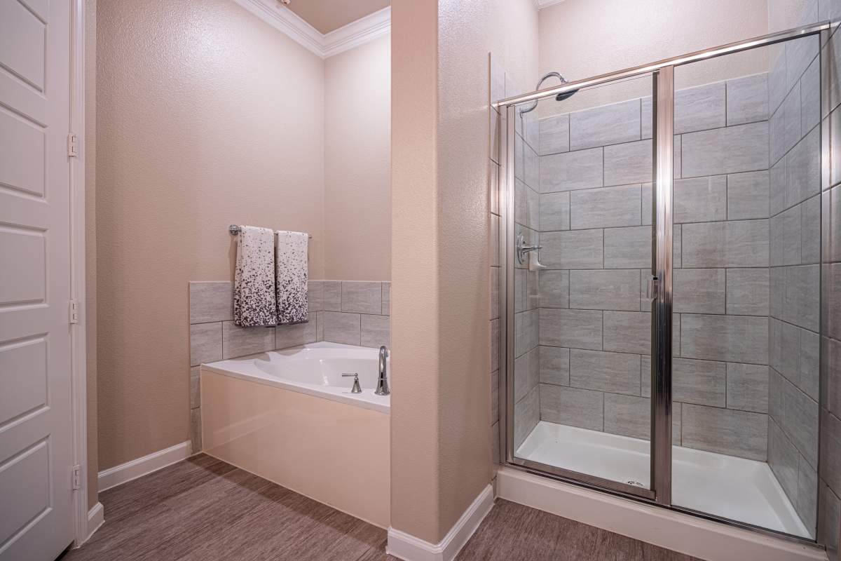 Bathroom with bathtub and glass shower at Century Travesia in Austin, Texas