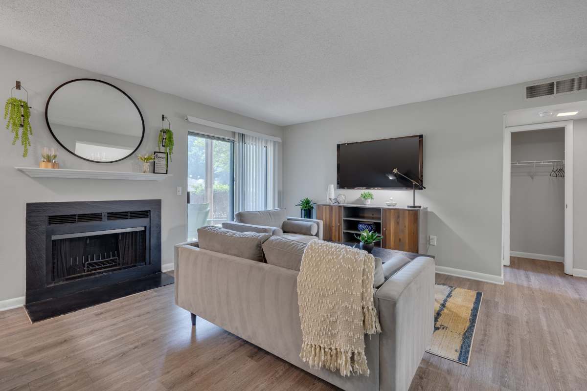 Living room with a comfortable couch and a TV at The Retreat at Lake Johnson Apartments, Raleigh, North Carolina