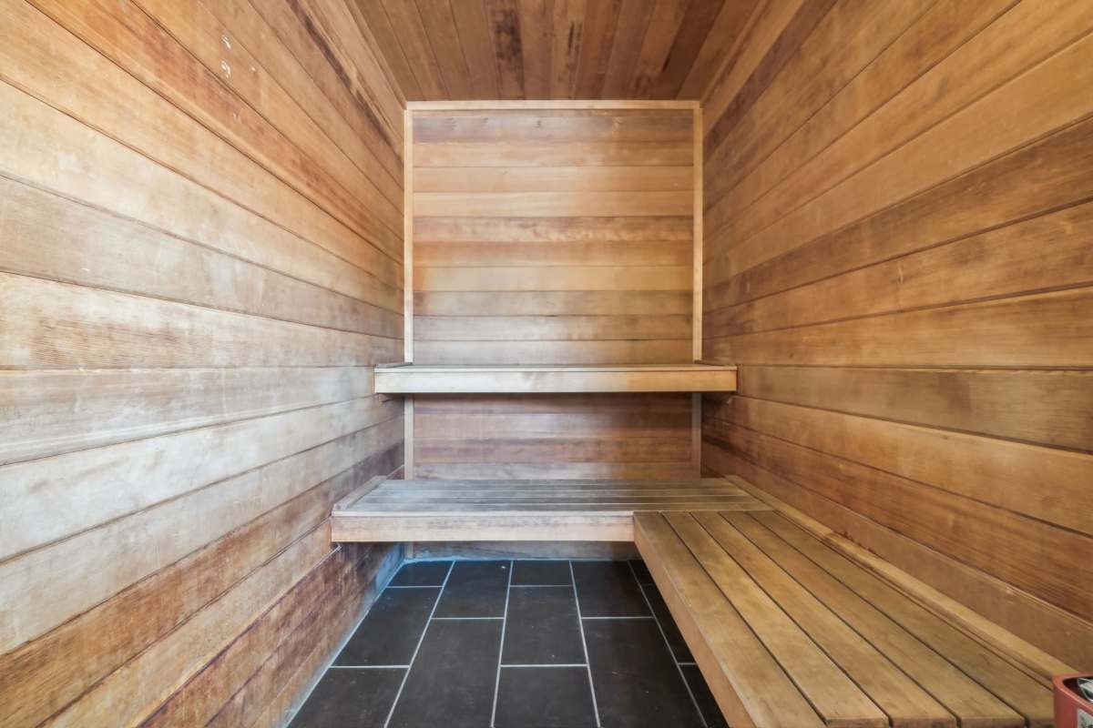 Interior of a wooden sauna with two-tiered benches and tiled floor at Pavilions at Silver Sage in Fort Collins, Colorado.